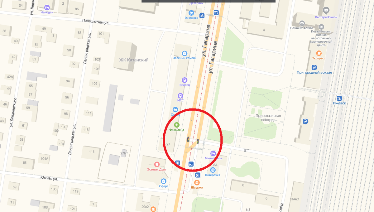 В выделенной области трамвайная и автобусная остановка "Железнодорожный вокзал". Трамваи останавливаются на проезжей части и совершают посадку и высадку пассажиров прямо на асфальт. Остановка платформой не оборудована, поэтому люди вынуждены переходить дорогу перед отъезжающими с остановки автобусами.