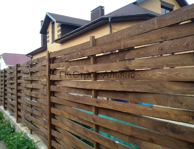 Обрезная доска заплетается между столбами.