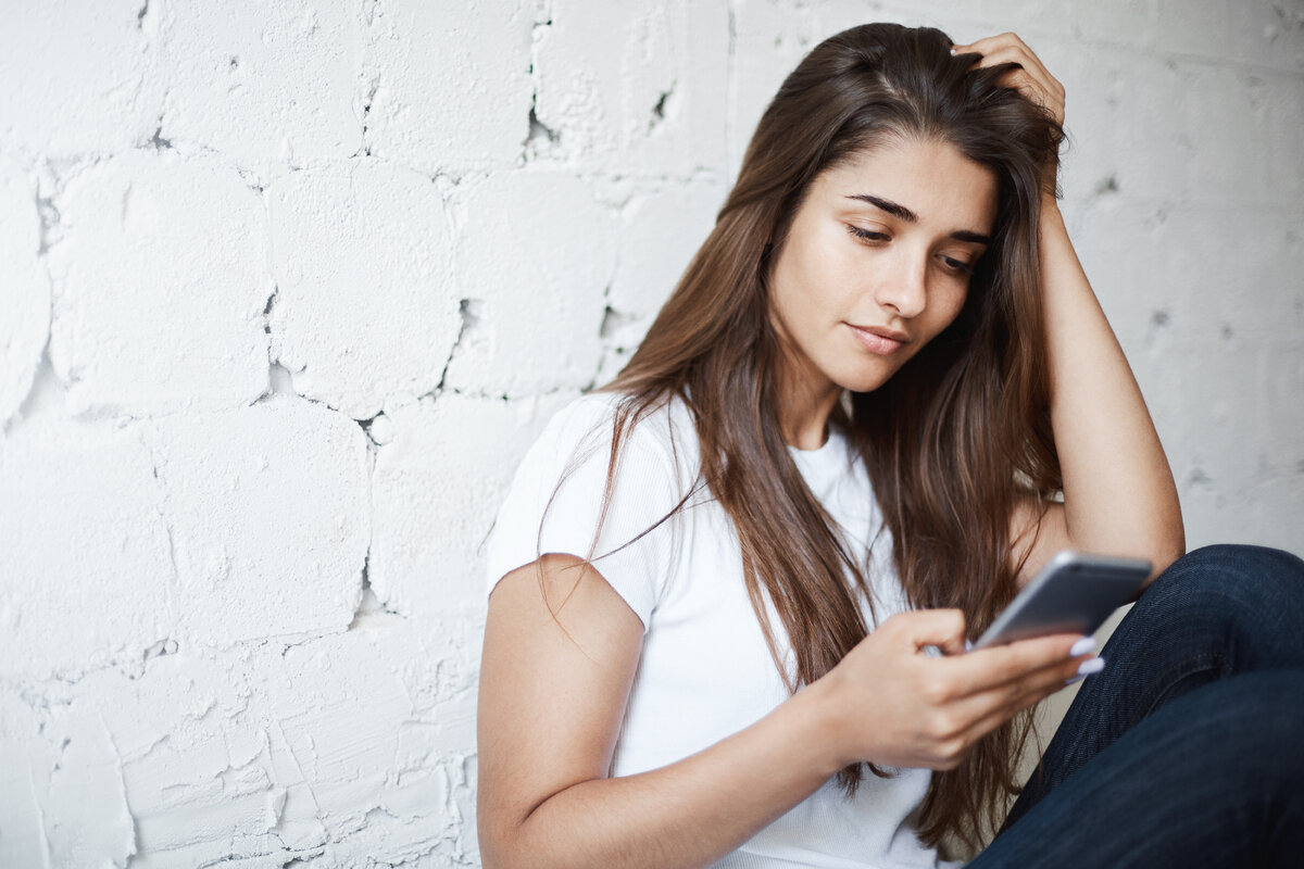 <a href="https://ru.freepik.com/free-photo/indoor-shot-of-smart-cute-brunette-woman-leaning-on-brick-wall-while-sitting-on-floor-and-browsing-internet-through-smartphone_13516505.htm#query=%D0%B3%D1%80%D1%83%D1%81%D1%82%D0%BD%D0%B0%D1%8F%20%D0%B4%D0%B5%D0%B2%D1%83%D1%88%D0%BA%D0%B0%20%D1%81%20%D1%82%D0%B5%D0%BB%D0%B5%D1%84%D0%BE%D0%BD%D0%BE%D0%BC&position=0&from_view=search&track=ais">Изображение от lookstudio</a> на Freepik