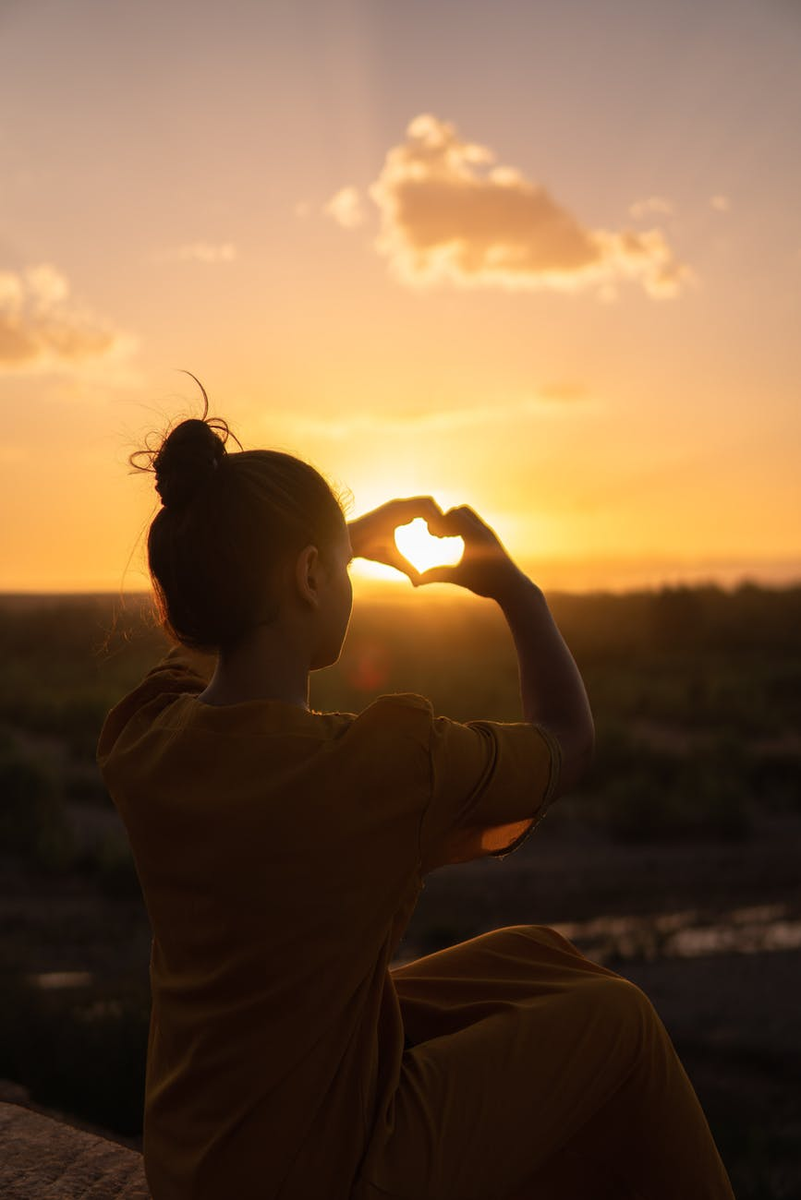 https://www.pexels.com/photo/woman-sitting-while-showing-heart-sign-hands-1535288/