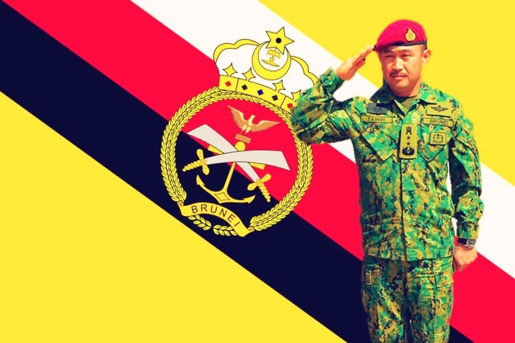 Фото 1. Офицер Королевских Вооруженных сил Брунея на фоне армейского флага