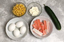 ШАГ 1:
Подготовить продукты. С кукурузы слить жидкость, можно окинуть ее на дуршлаг, чтобы хорошенько просушить. Яйца помыть и отварить. Варите их в течении 10 минут после закипания на маленьком огне, а затем оставьте ненадолго в горячей воде - так яйца будут полностью сваренными, но останутся при этом мягкими. Затем залейте яйца холодной водой. Огурец надо хорошо помыть и обсушить. Если крабовые палочки замороженные - разморозьте их.