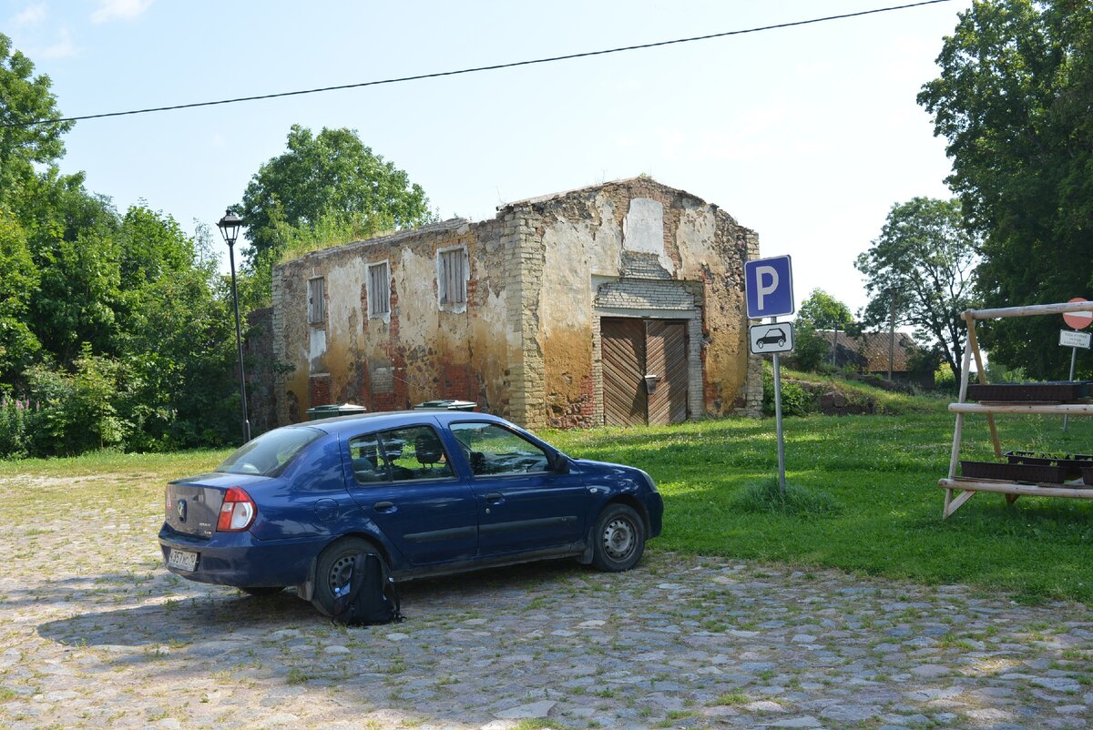 Парковка в усадьбе "Кукрузе". На заднем плане - здание зерносушилки с провалившейся крышей