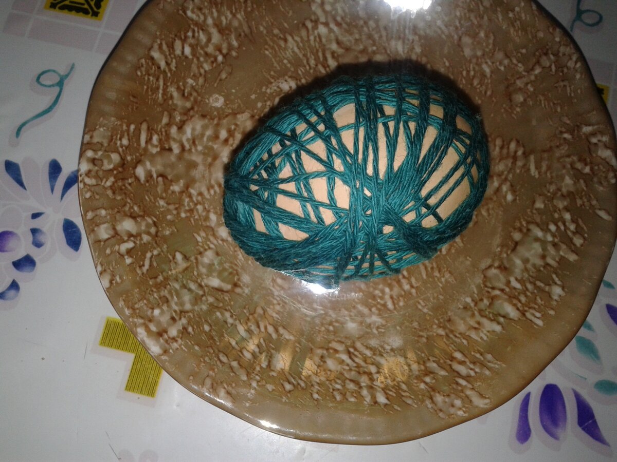 Обмотаем сырое яйцо нитками с промежутками.