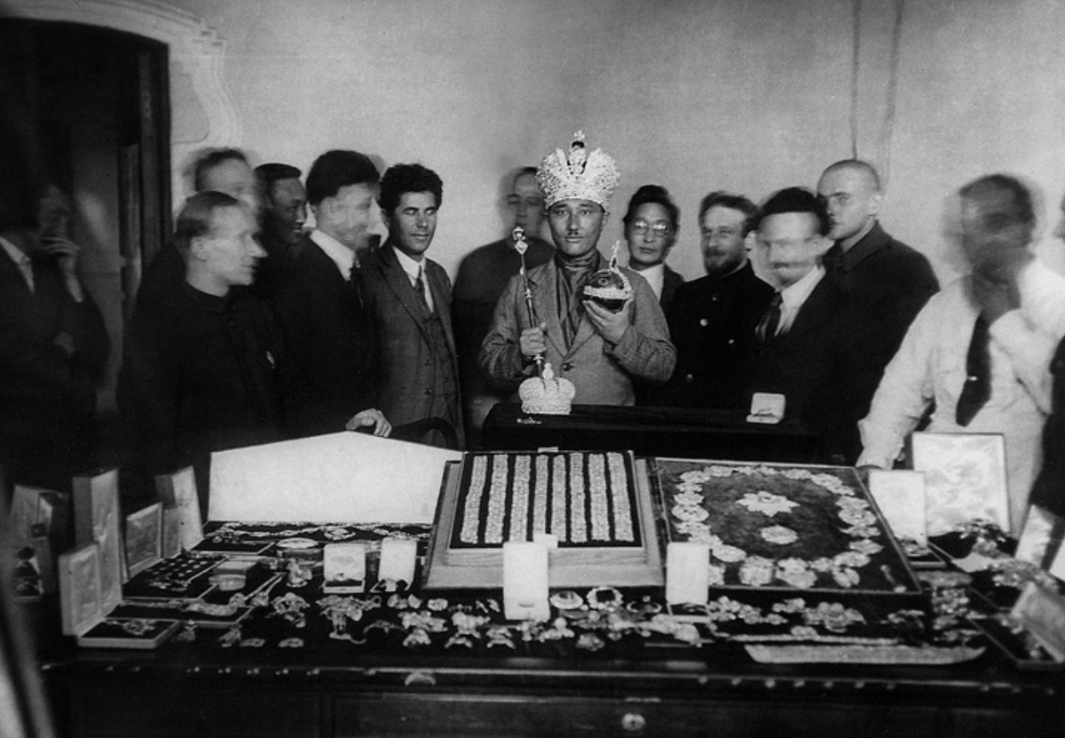 Один из иностранных гостей Гохрана примеряет корону российских императоров. В руках у него символы царской власти – скипетр и держава. Дата съемки: 1923 год. Фото взято с сайта russianphoto.ru