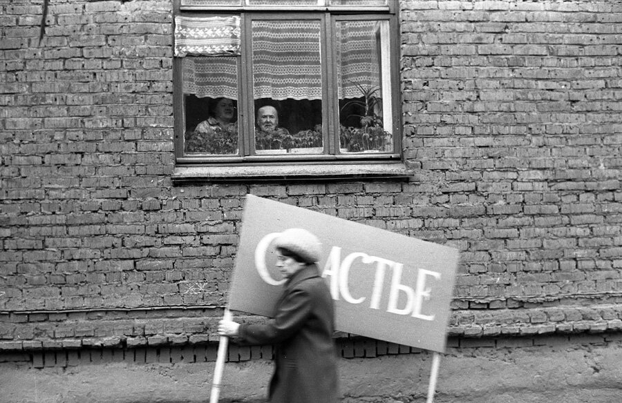Владимир Соколаев. Женщина с плакатом спешит на первомайскую демонстрацию. Новокузнецк. 1983