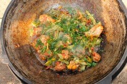 ПОШАГОВОЕ ПРИГОТОВЛЕНИЕ

ШАГ 1:
Подготовьте все необходимые продукты, которые понадобятся для приготовления стручковой фасоли с курицей в казане на костре. Курицу нарежьте кусками, лук и чеснок почистите, помидоры, фасоль и зелень ополосните под проточной водой.
ШАГ 2:
Разожгите костёр и установите казан.
ШАГ 3:
Когда казан хорошо прогреется, налейте в него растительное масло, оставьте на несколько минут, пока масло не раскалится. Одну луковицу разрежьте пополам и закиньте обжариваться, оставьте до тех пор, пока не появится золотистая корочка. Выловите обжаренный лук с помощью шумовки.
ШАГ 4:
В казан отправьте курицу. Костёр поддерживайте на максимуме, так как на этом этапе нужно обжарить кусочки до золотого цвета.
ШАГ 5:
Непрерывно помешивая, готовьте курицу от 5 до 10 минут. Затем налейте кипяток так, чтобы он наполовину покрывал кусочки мяса. Накройте казан крышкой, огонь сделайте умеренным и готовьте курочку от 30 до 50 минут. Время готовки зависит от того домашняя ли у вас птица, либо покупная. Мясо должно дойти практически до готовности. У меня на это ушло около 50 минут.
ШАГ 6:
В это время подготовьте зелёную фасоль. Если она немолодая, то удалите хвостики и усики с обеих сторон. Нарежьте стручки на 2 или 3 части, как на фото.
ШАГ 7:
По истечении указанного времени, проверьте много ли жидкости осталось в казане. Если да, то подкиньте дров, увеличьте костёр и помешивая шумовкой, выпарите лишний сок. Добавьте мелко нашинкованный лук.
ШАГ 8:
Готовьте около 5 минут, лук должен слегка поджариться.
ШАГ 9:
Далее идёт очередь нарезанных помидоров и фасоли.
ШАГ 10:
Аккуратно всё перемешайте, посолите, поперчите по вкусу и приправьте любимыми специями.
ШАГ 11:
Накройте казан крышкой и оставьте на слабом костре до полной готовности фасоли. Время приготовления зависит от того, насколько молодая фасоль у вас ( мне потребовалось около 30 минут). Периодически открывайте крышку, если фасоль начинает пригорать, то добавьте совсем немного кипятка. Если помидоры сочные, то их вполне хватает для приготовления без добавления воды.
ШАГ 12:
Готовое блюдо посыпьте мелко нарезанным чесноком и зеленью. Можно подавать!