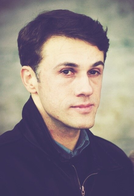 Я не понимаю, почему он у меня ассоциируется с хлебушком. Не спрашивайте, это за гранью моего собственного понимания, но вот смотрю на это фото и в голове - "О" Хлебушек!". Ну, если уж пройтись конкретно по его физии - то глазки маленькие, под ними мешки, и видимо, именно это и портит всю картину, потому что остальное вроде приличное. 
_____________________________________________________________________________________________________________