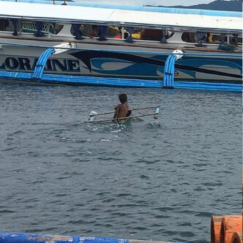 Судно из бамбука и веревок, на котором филиппинские дети гоняют по территории порта.