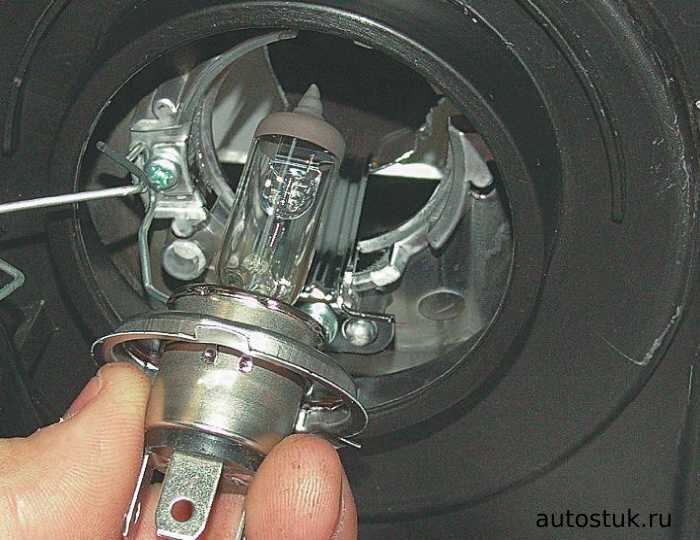 Снять лампу. Для этого снять резиновую заглушку, взять за контактную колодку и отсоединить штекер от лампы. Надавить лампу, повернуть и вытащить из колодки.