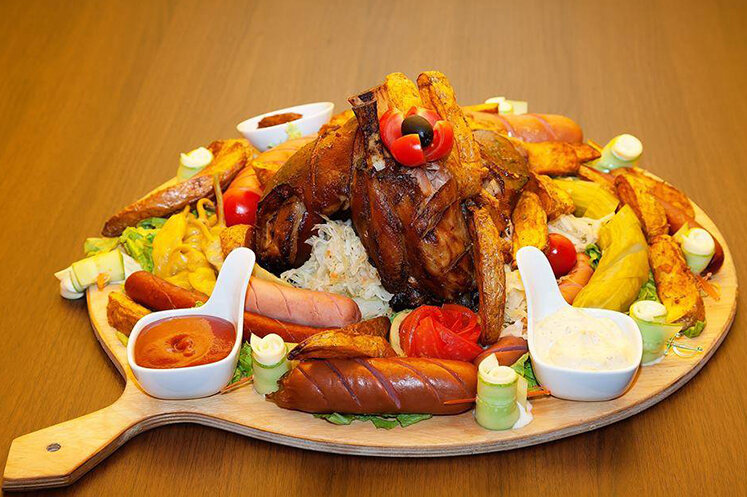 Канчи - это свиная ножка(рулька) запеченная в духовке, с разнообразным гарниром: картошка, соления, соусы, сардельки, сосиски, овощи. 