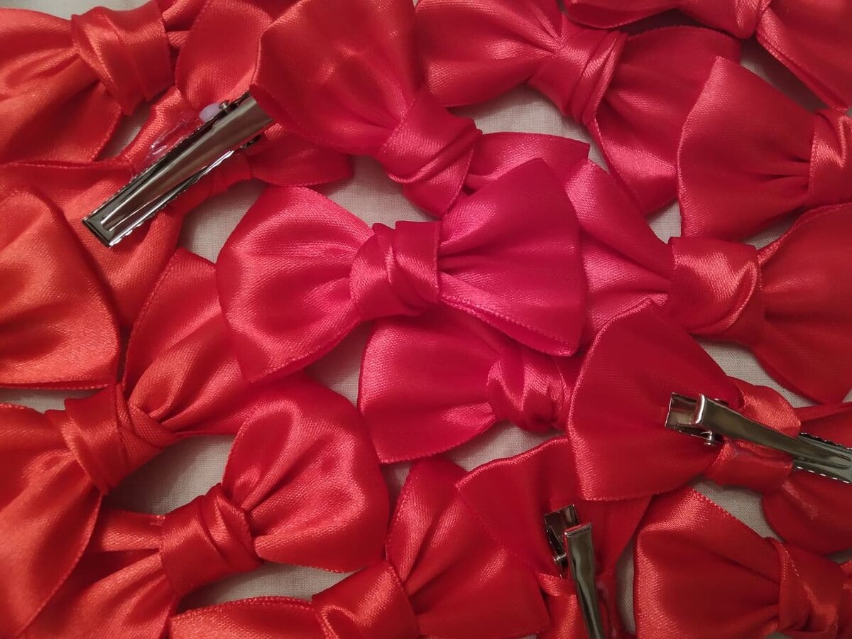 20 бантиков из красной атласной ленты на заколках-крокодильчиках. Такие же еще будут, возможно, белые или темно-синие.