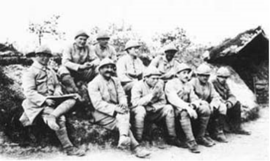 Уильям Дуган (крайний слева) с другими американскими легионерами вскоре после их перевода в 170-й линейный пехотный полк, октябрь 1915 года. Пол Павелка сидит в верхнем ряду, 2-й слева. Еще один будущий пилот «Лафайет» - Мариус Рокл (в первом ряду в центре). Обратите внимание на опухший и почерневший левый глаз Дугана - результат осколочного ранения во время боя в «Буа-де-Сабо». 