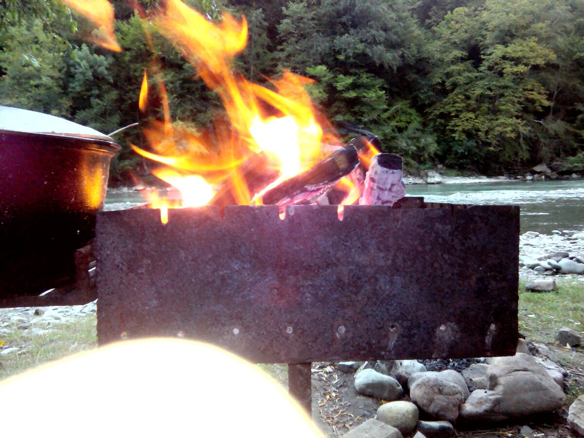 Мангал с костром на фоне реки