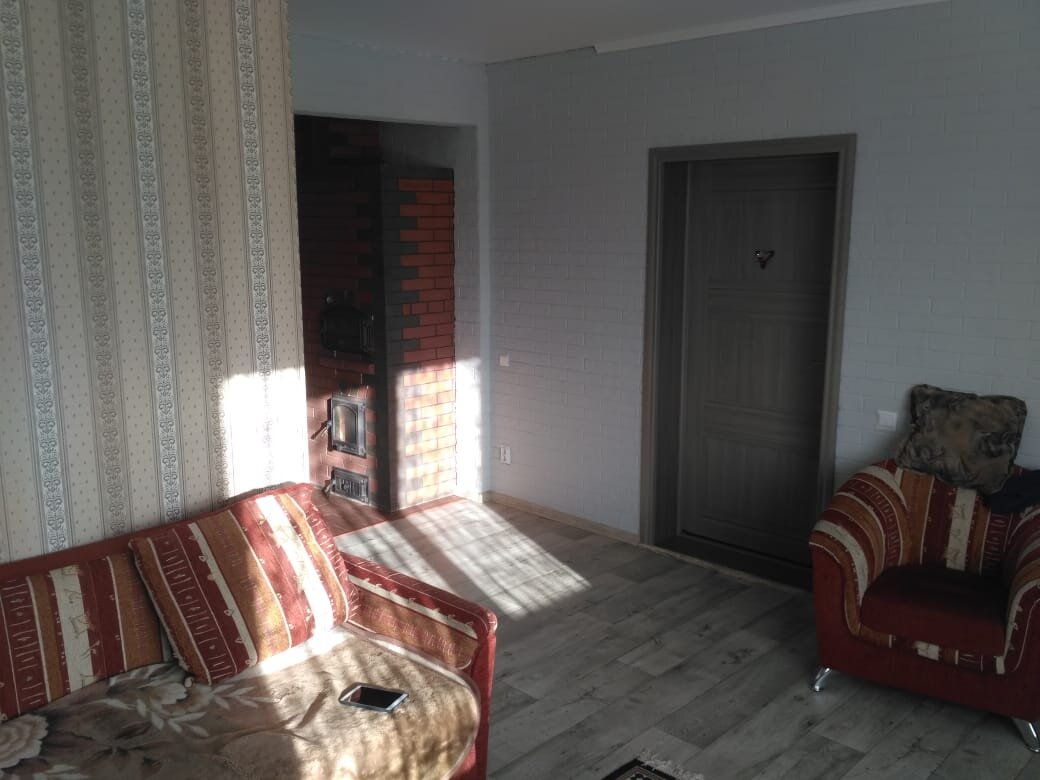 Гостиная с видом на печь и входную дверь из прихожей.