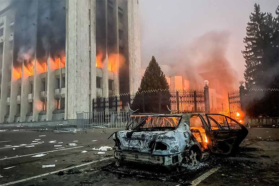 Казахстан. Алма-Ата. Сгоревший автомобиль возле горящего здания мэрии (акимат). - Фото: Валерий Шарифулин/ТАСС