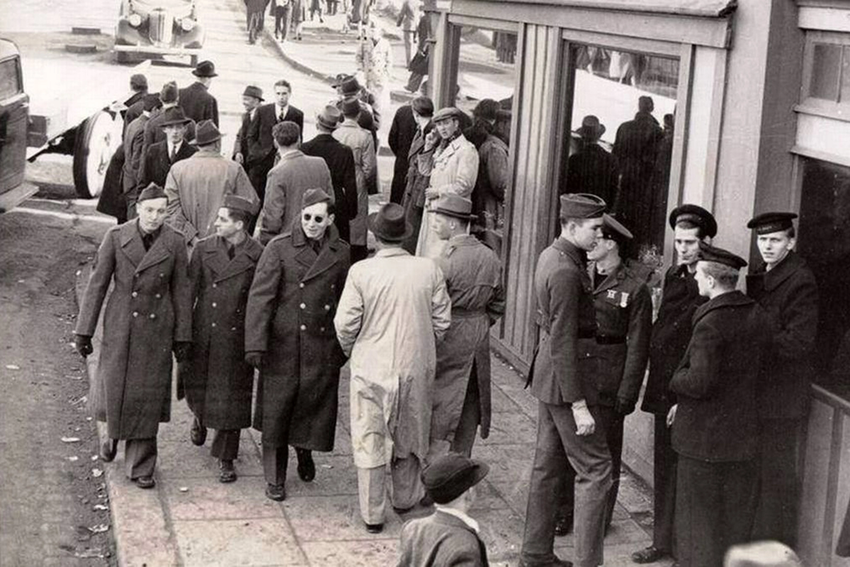 Фотография 1943 года, на которой изображён предполагаемый путешественник во времени. Это мужчина в пальто, прислонившийся к витрине