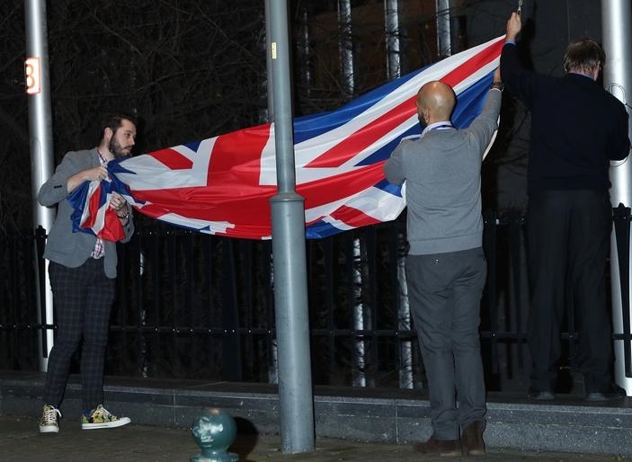Снятие флага с флагштока возле здания Европарламента в Брюсселе.