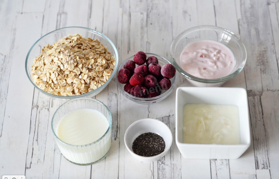 Как делать ленивая овсянка с йогуртом? Подготовить ингредиенты. Для приготовления ленивой овсянки в банке нам понадобится: 150 г овсяных хлопьев быстрого приготовления; 100 мл молока; 120 г вишневого йогурта; 120 г йогурта без добавок; 50 г замороженной вишни; 1 ст. л. семян чиа (по желанию).