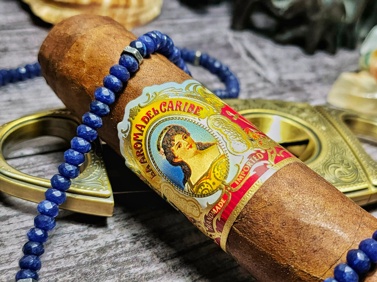 Бренд La Aroma De Cuba - популярный и уважаемый бренд кубинского происхождение. Но после прихода режима Фиделя Кастро в 1959 году и в последующем национализации предприятий, производству пришлось переместиться в Никарагуа. Одним переездом дело не обошлось, чтобы избежать юридических противоречий из-за наличия в наименовании слова Cuba, бренд сменил название, и на данный момент известен Европе и Азии как La Aroma Del Caribe.