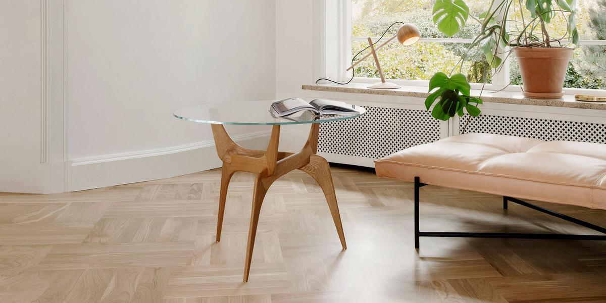 Обратите внимание, как современный стол из массива «трайо» вписывается в биофильный дизайн комнаты с естественным солнечным светом, растениями в горшках и паркетными полами. www.erasnabmebel.ru 