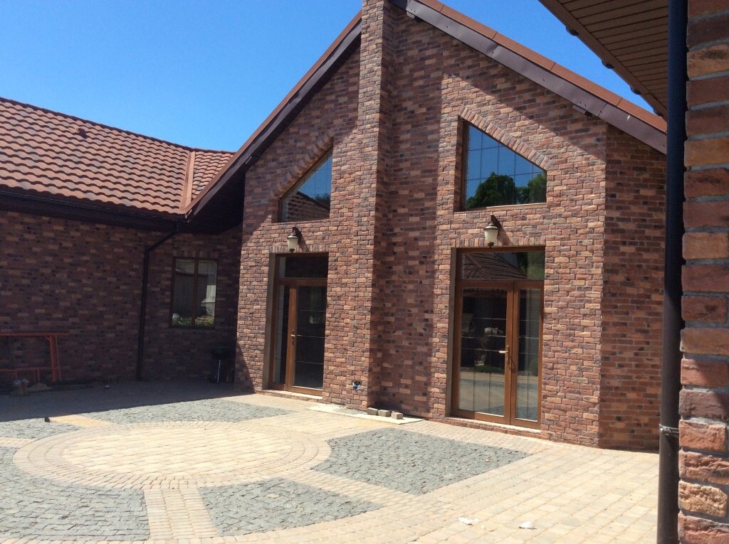 Облицовка фасада частного дома декоративным камнем из бетона