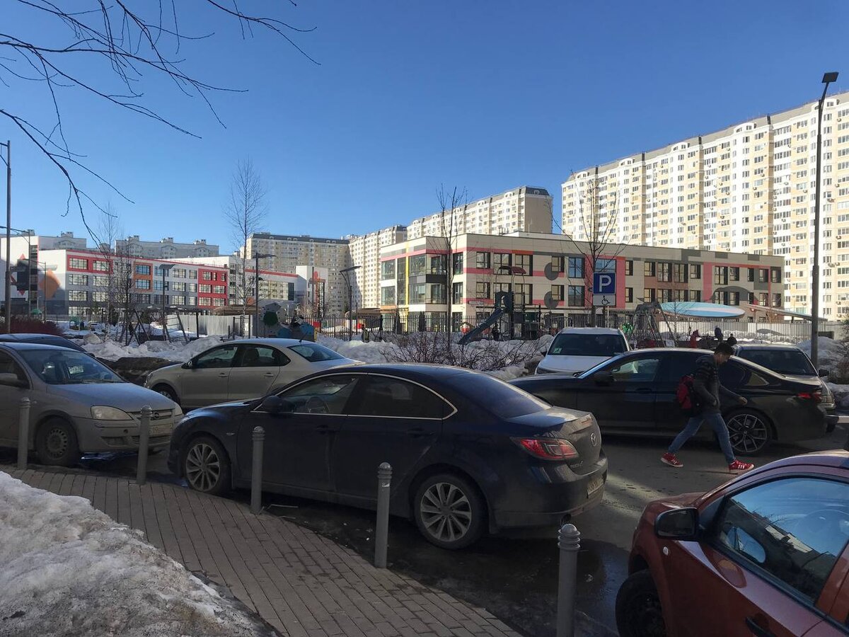 Вокруг всё запарковано автомобилями 