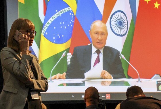    Президент России Владимир Путин (на экране) участвует по видеосвязи в заседании саммита БРИКС