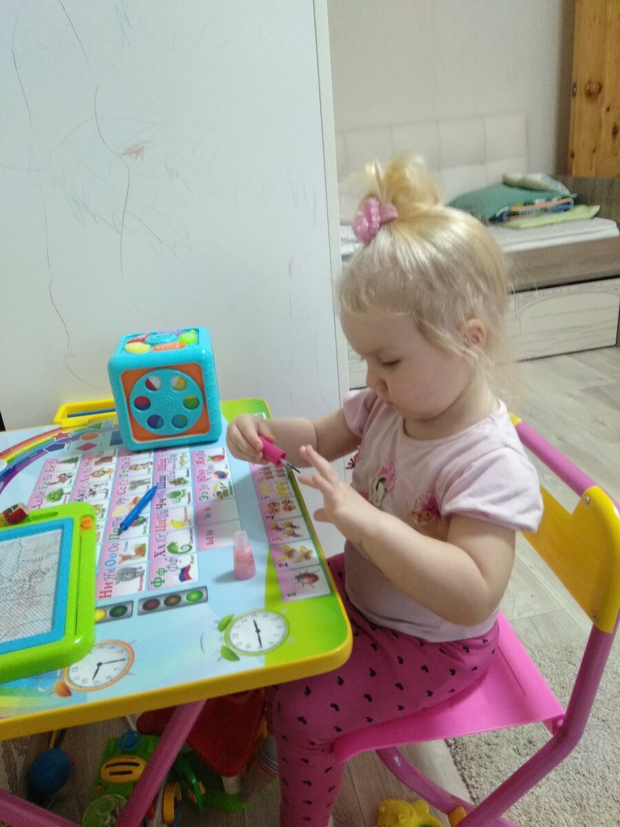 Дочка красит ногти детским лаком.