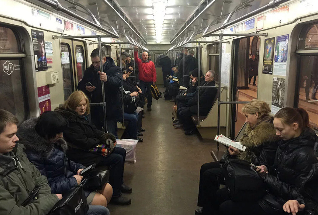 Фотографируют в метро. Люди в вагоне метро. Вагон метро. Вагон метро с пассажирами. Люди едут в метро.