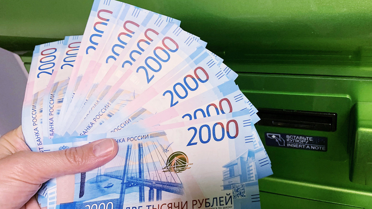    Клиент Сбербанка вносит наличные деньги в банкомат© РИА Новости . Наталья Селиверстова