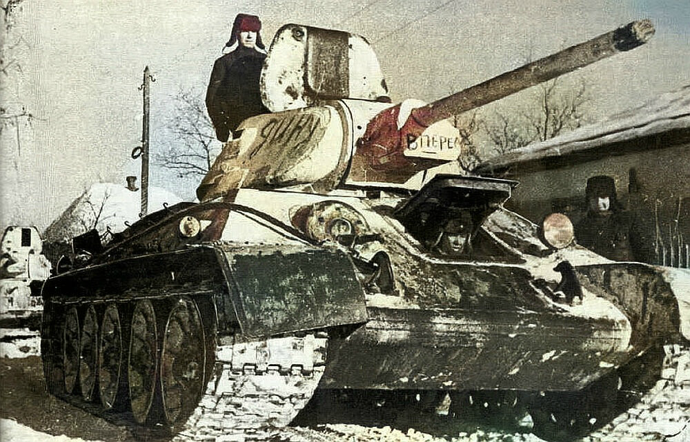 Танк Т-34 проходит через освобождённую деревню. Январь 1942 года.