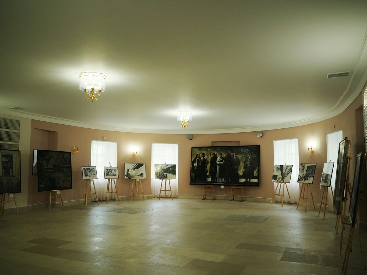 Овальный зал на первом этаже дома, в котором встречали гостей усадьбы. Сейчас тут проходит выставка работ современных художников, посвящённых блокаде Ленинграда в годы ВОВ.