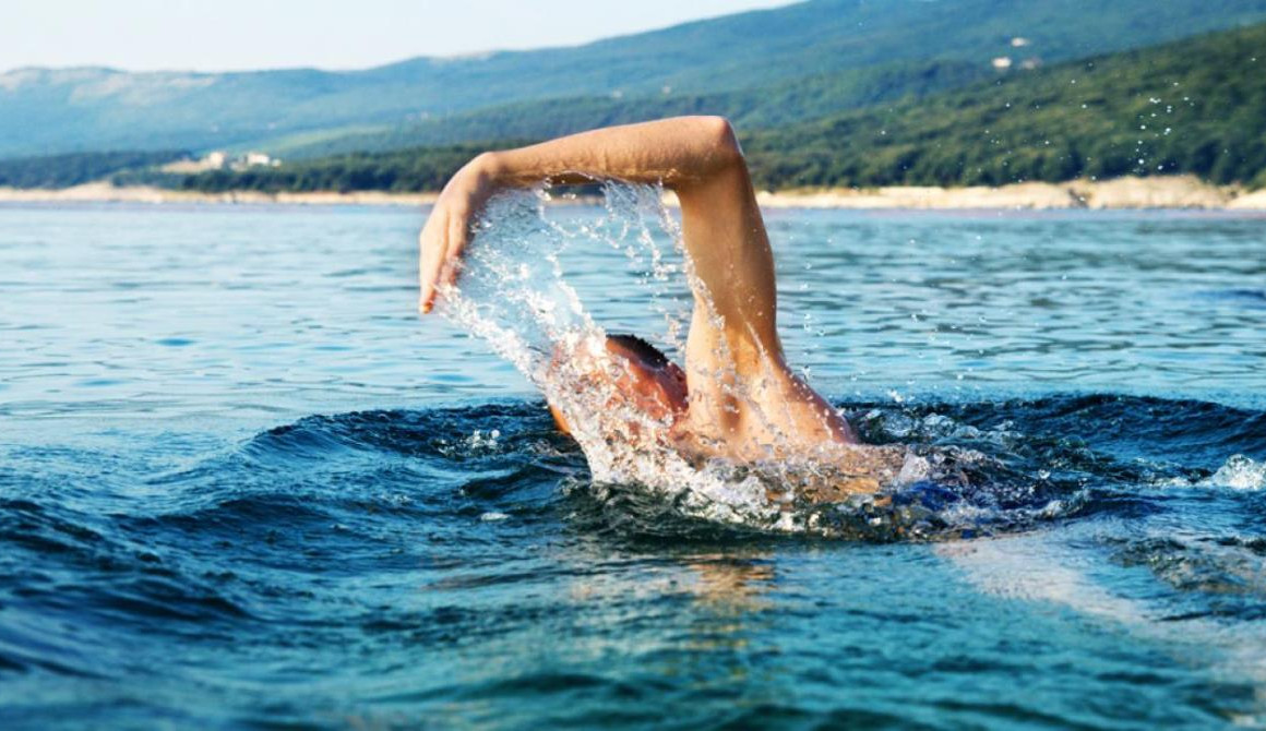 Глупое море. Человек плывет. Человек плавает. Пловец в море. Купание в естественных водоемах.