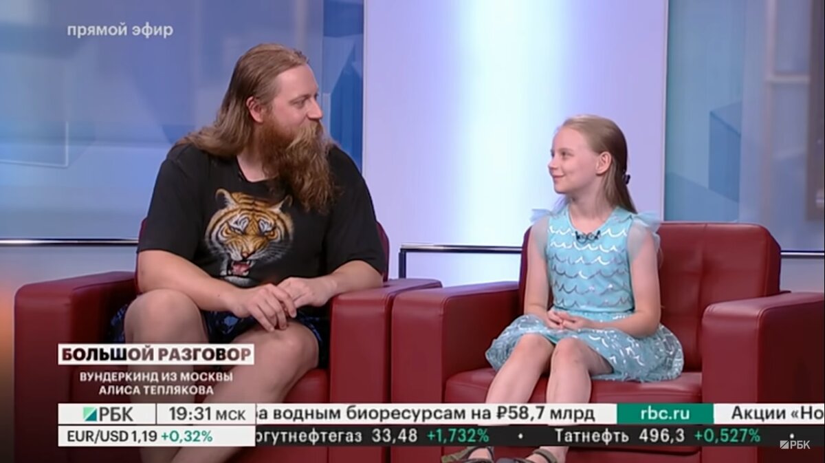 Папа Евгений Тепляков в пляжных шортах (в них он на всех опубликованных фото) и футболке с изображением головы тигра, совершенно не подходящий наряд даже с учётом жаркой погоды. Дочь Алиса Теплякова в нарядном платье, подаренном на день рождения, вполне подходяще. Скриншот телепередачи РБК "Большой разговор"