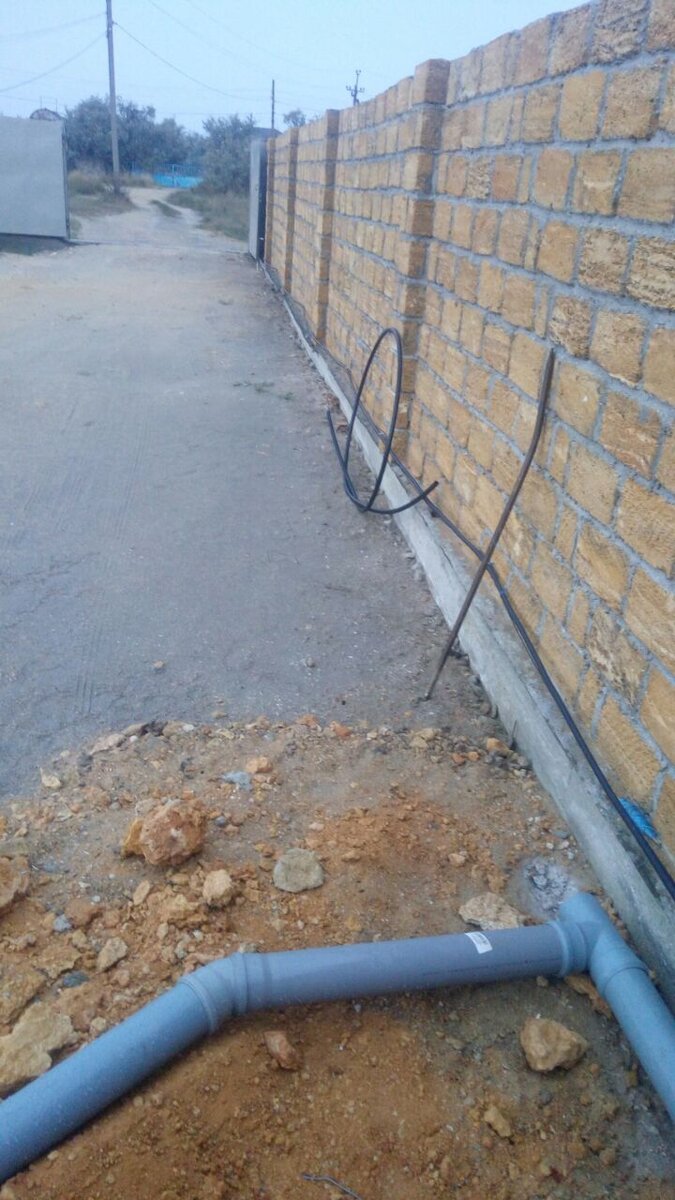 Канализация начинается тут ( в торце бытовки), идет вдоль забора, заворачивает вдоль забора налево и доходит почти до конца стены. В том углу планируется дом. Общая длинна канализации получилась порядка 45 метров.
