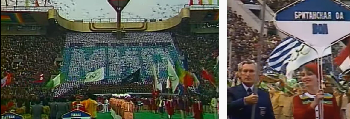 Парад флагов.  Видно несколько белых флагов с олимпийскими кольцами, а также черный флаг (в центре).   На фото справа - табличка с надписью "Британская ОА".