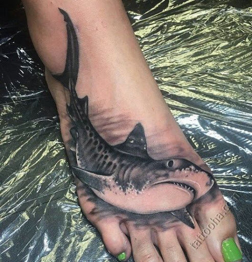 Татуировка тигровой акулы на ноке у девушки