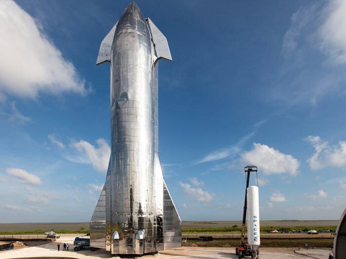 Прототип Starship Mark 1 рядом с первой ступенью ракеты Falcon 1 - первой ракеты компании SpaceX, построенной 11 лет назад.