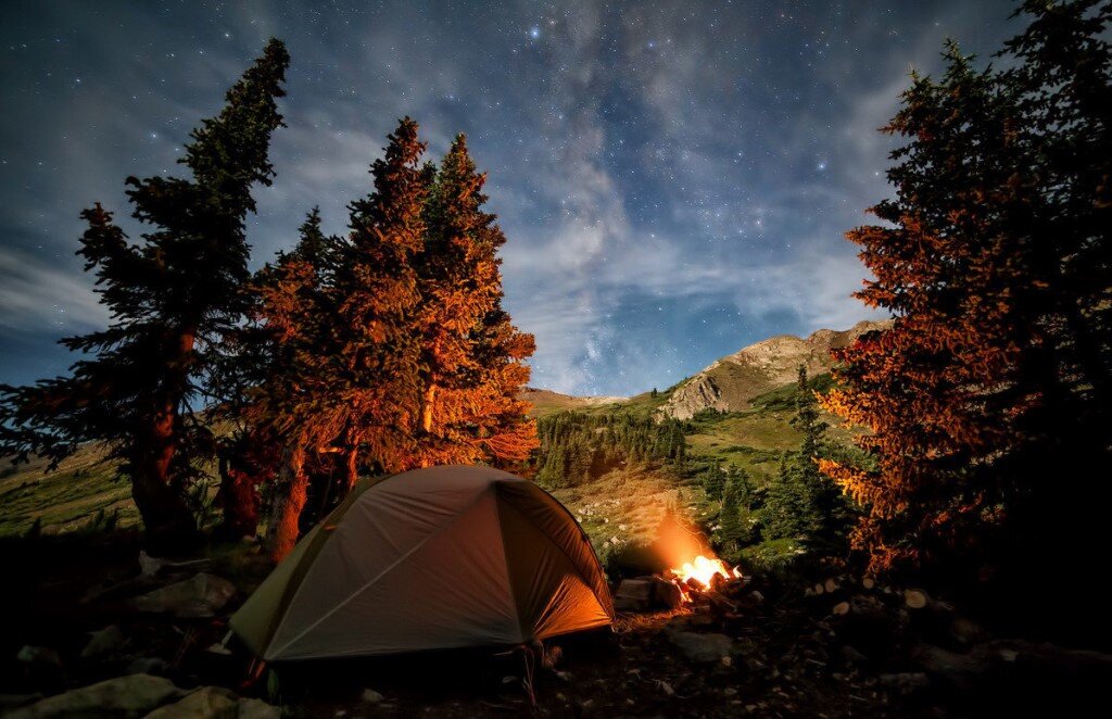 1) Костер лучше разжигать на расстоянии 1,5 - 2 метров от палатки или укрытия. Если поставить ближе, искры могут подпалить снаряжение, дальше – тепло от костра не будет греть вас в палатке. И конечно, костер следует разжигать с подветренной стороны убежища, чтобы искры не летели в его сторону.