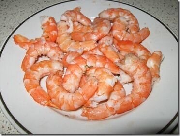     Конечно, можно купить уже готовые замороженные креветки, но я предпочитаю сама готовить креветки дома. Поэтому нам необходимо для начала приготовить овощной отвар в котором мы будем варить креветки.       Наливаем в кастрюлю воды, ставим её на огонь. Берём одну луковицу, очищаем и режим пополам. Добавляем лук, 2 -3 веточки укропа или петрушки, пару горошин душистого перца, лавровый лист и соль в кастрюлю с водой. Отвар доводим до кипения и варим минут 15 на слабом огне. Затем из отвара удалить лук и специи, и положить в кастрюлю, заранее помытые, креветки. Как только креветки перестанут быть прозрачными, можно поварить их ещё 5-10 минут и затем вытаскиваем.       Остужаем креветки и очищаем их от панциря.   
