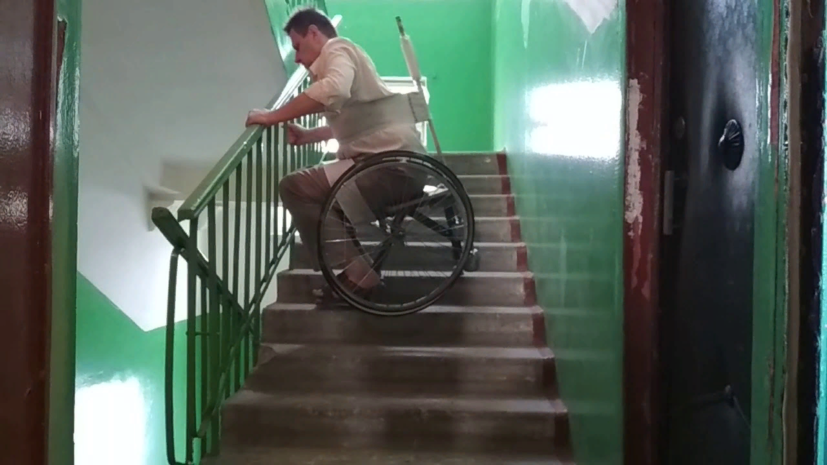 Подниматься по лестнице в подъезде. Кресло инвалидное для подъема по лестнице. Инвалидная коляска спускающаяся по ступенькам. Лифт для спуска инвалидной коляски по лестнице. Инвалид на коляске и лестница.
