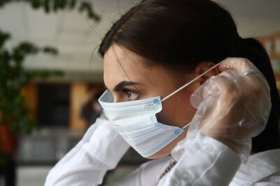    Девушка надевает средства индивидуальной защиты во время демонстрации работы модельного участка для общероссийского голосования по поправкам в Конституцию РФ в лицее No9 Новосибирска. Смоделированный участок - пример того, как будут оборудованы помещения для голосования в Новосибирской области с учетом санитарно-эпидемиологических норм и рекомендаций Роспотребнадзора в день общероссийского голосования по поправкам в Конституцию Российской Федерации. ©Александр Кряжев РИА Новости