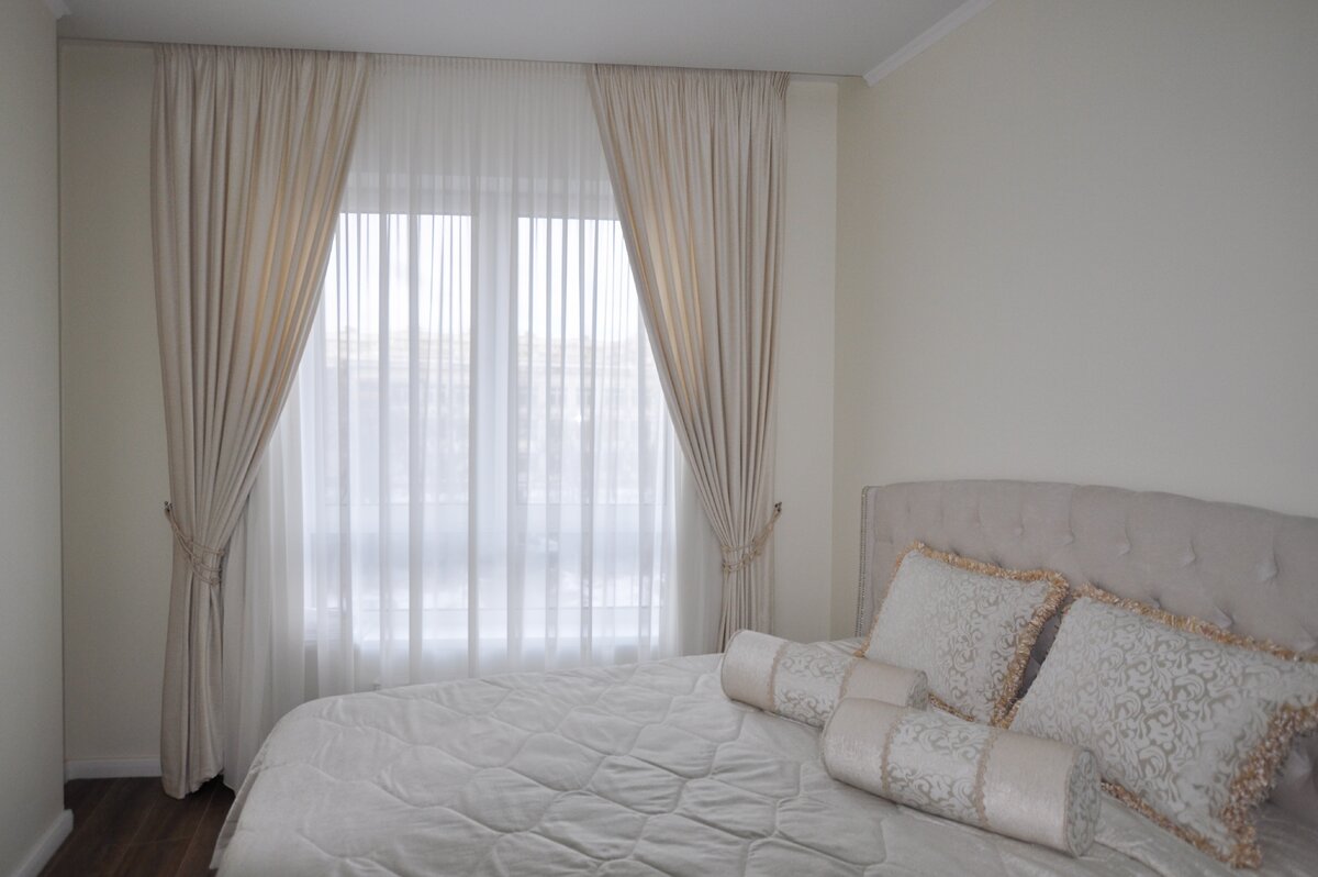 Небольшое помещение расширяем визуально за счет светлых, близких к цвету стен шторами и покрывалом. Можете здесь представить темные цвета?