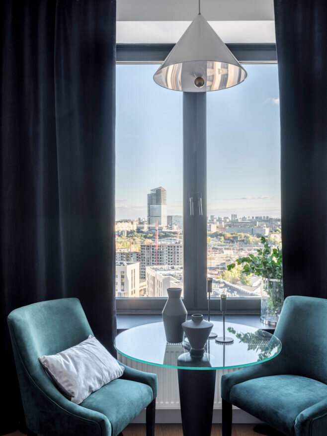 Фрагмент гостиной. Из окон квартиры открываются живописные виды, поэтому дизайнер разместила обеденный столик у окна. Стол, Respectli; кресла, Lavsit.