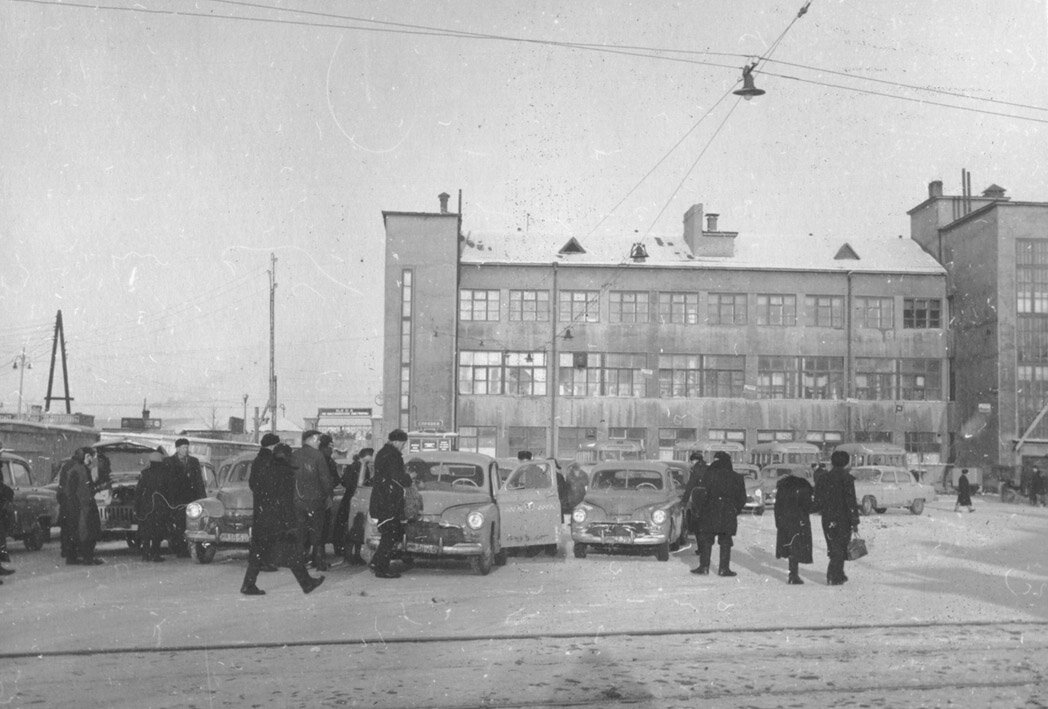 Стоянка такси у железнодорожного вокзала.1960 г. Фото предоставлено Садковым Д.В.Место съемки: пл. Привокзальная. Источник: http://ivmk.net/lithos-oldivan05.htm