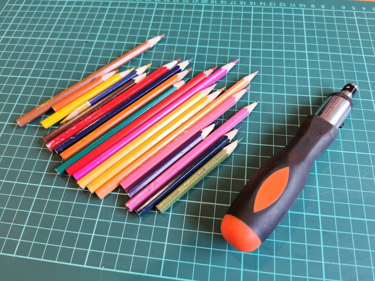 Цветные карандаши и отвертка с трещёткой.