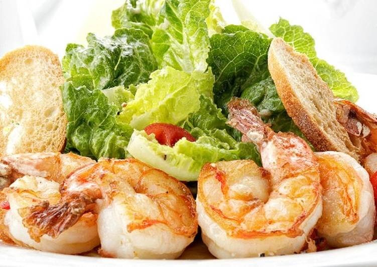 Цезарь с креветками – один из вариантов популярного во всем мире салата. И хотя самый первый салат цезарь не содержал продуктов животного происхождения, со временем в него стали добавлять яйца, курицу, индейку, креветки, семгу, тунца, бекон, ветчину.

Рецепт:
400 г креветки
300 г салат
3-4 шт. черри
2 шт. яйцо
2-3 зубчика чеснок
3-4 ст. л лимонный сок
1,5 ч. л. (если есть) вустерширский соус
200 г белый хлеб
150 мл оливковое масло
1 ч. л. сахар
1 ч. л. (бальзамический) уксус
по вкусу черный перец
по вкусу соль
1 ч. л. горчица

1) С белого батона срезаем корочку, режем хлеб кубиками со стороной 1-2 см и обжариваем его на оливковом масле с чесноком до зарумянивания, периодически перемешивая. Перекладываем сухарики на противень и подсушиваем их духовке 5-10 минут на среднем огне (около 180 градусов). По желанию посыпаем сухарики итальянскими травами.

2) С белого батона срезаем корочку, режем хлеб кубиками со стороной 1-2 см и обжариваем его на оливковом масле с чесноком до зарумянивания, периодически перемешивая. Перекладываем сухарики на противень и подсушиваем их духовке 5-10 минут на среднем огне (около 180 градусов). По желанию посыпаем сухарики итальянскими травами.

3) Для заправки варим яйца всмятку – минуту в кипятке. Извлекаем желтки и взбиваем их с горчицей, 2 столовыми ложками лимонного сока, бальзамическим уксусом, 4 столовыми ложками оливкового масла с чесноком, солью, сахаром и щепоткой черного перца.

4) Если готовим с вустерским соусом, то для заправки берем столовую ложку лимонного сока, 4 столовые ложки оливкового масла, по чайной ложке горчицы и вустерского соуса, два желтка и соль с перцем по вкусу.

5) Теперь наш салат надо собрать. Руками рвем листья салата и рассыпаем их на тарелку. Сверху выкладываем гренки, порезанные пополам черри и креветки. Поливаем соусом и посыпаем натертым пармезаном.

6) Приятного аппетита!