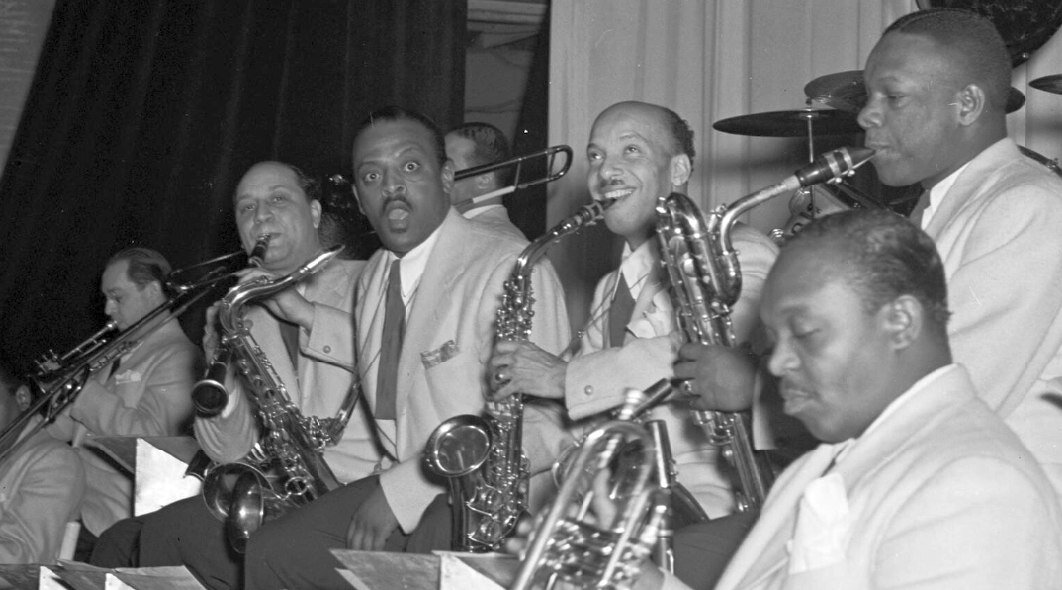 Участники оркестра Дюка Эллингтона: Хуан Тизол, кларнетист Барни Бигард, тенор-саксофонист Бен Уэбстер, альтист Отто «Тоби» Хардвик, корнетист Рекс Стюарт, баритон-саксофонист Харри Карни. Около 1938. Фото: Уильям Готтлиб (William P. Gottlieb/Ira and Leonore S. Gershwin Fund Collection, Music Division, Library of Congress)