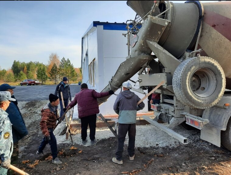 Заливают отмостку возле здания